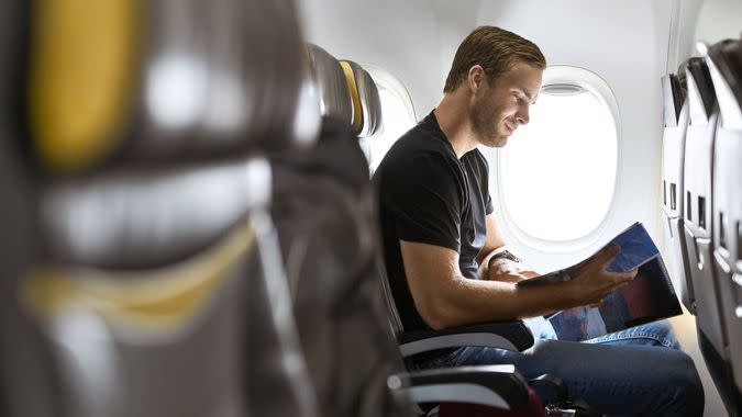 man reading magazine on airline