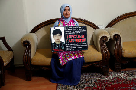 Gulgine Mahmut holds a placard with a picture of her son Pakzat at her home in Istanbul, Turkey, December 12, 2018. REUTERS/Murad Sezer