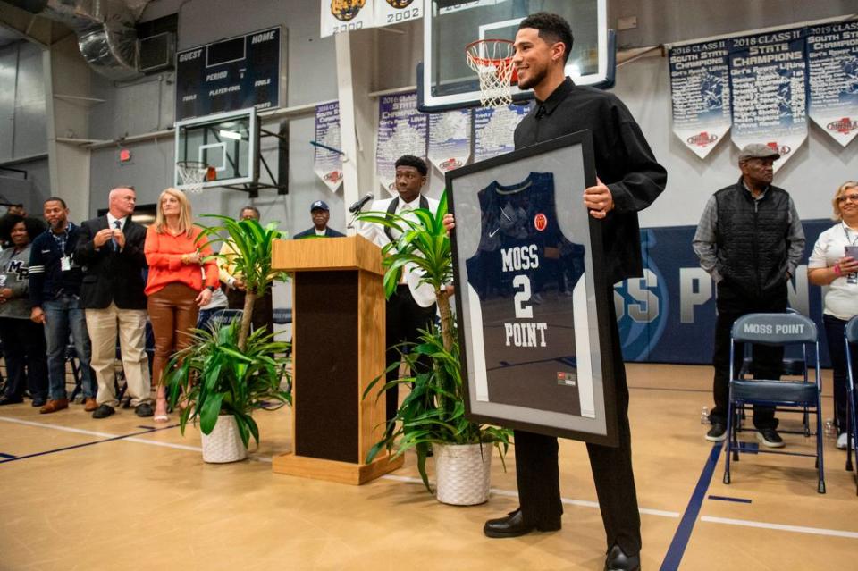 NBA star Devin Booker poses with his high school jersey during a ceremony for the retirement of Booker’s high school number at Moss Point High School in Moss Point on Saturday, Dec. 10, 2022.