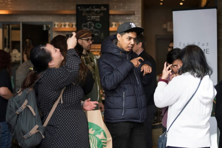 People sign with each other as they stand in line at the first US Starbucks "signing store"