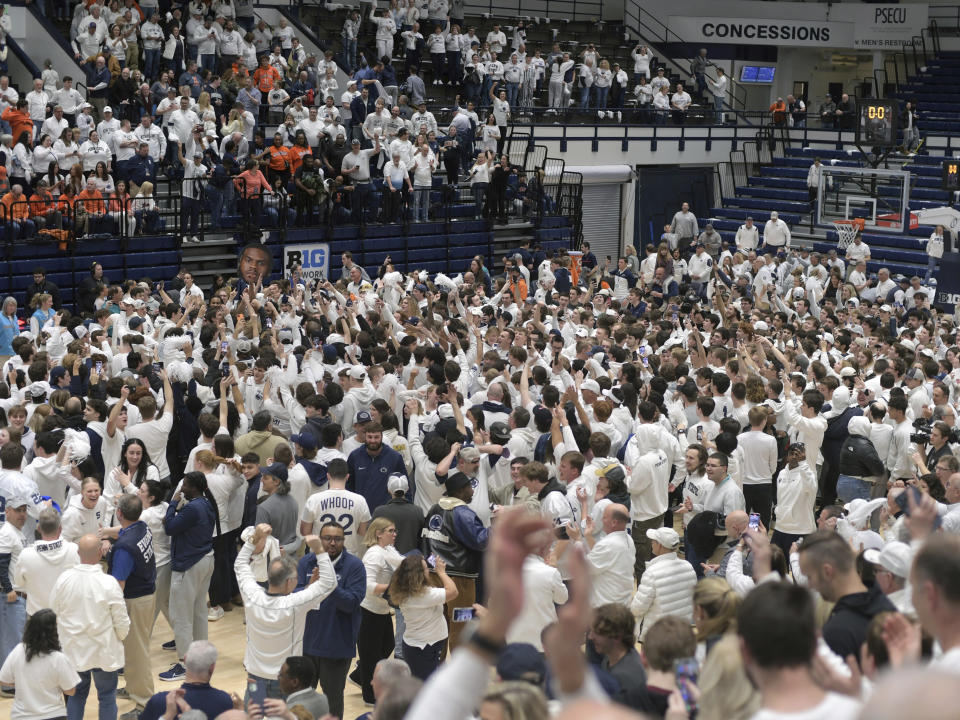 Penn State fans rush the court after Penn State defeated Illinois 90-89 in an NCAA college basketball game Wednesday, Feb. 21, 2024, in State College, Pa. (AP Photo/Gary M. Baranec)