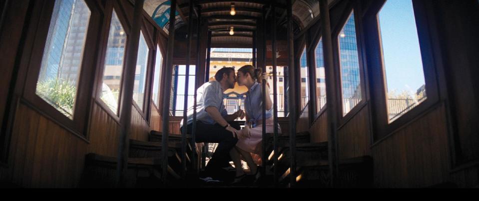 In this undated photo from the Oscar-winning film "La La Land" provided by Lionsgate, actors Ryan Gosling and Emma Stone kiss aboard a railcar on Angels Flight, a tiny railroad in downtown Los Angeles, that has been shut down since 2013. Los Angeles officials announced on Wednesday, March 1, 2017, that the antique railroad should be back in service by Labor Day. (Courtesy of Lionsgate via AP)