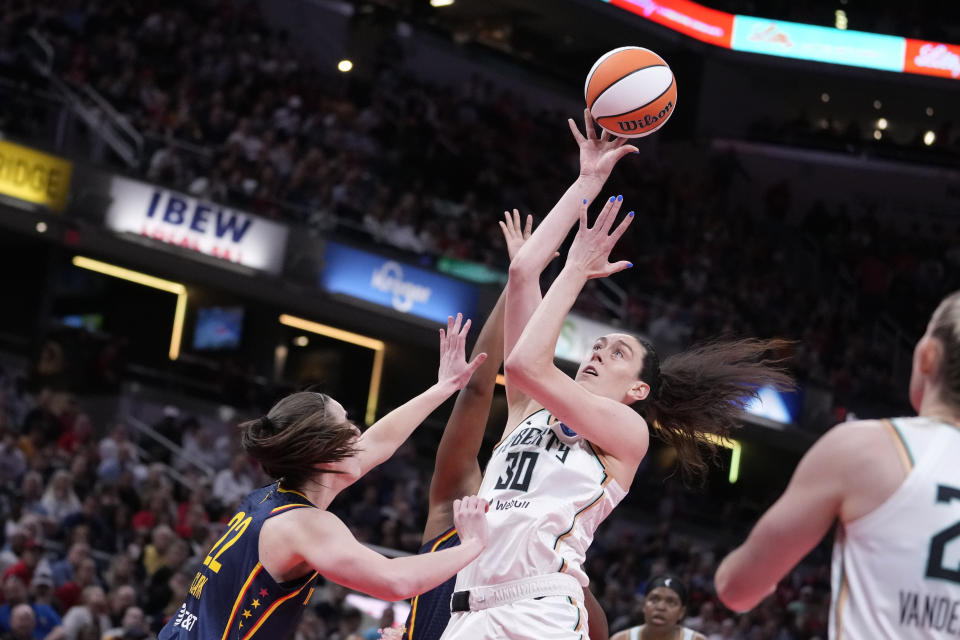 New York Liberty forward Breanna Stewart (30) shoots over Indiana Fever guard Caitlin Clark (22) in the first half of a WNBA basketball game, Thursday, May 16, 2024, in Indianapolis. (AP Photo/Michael Conroy)