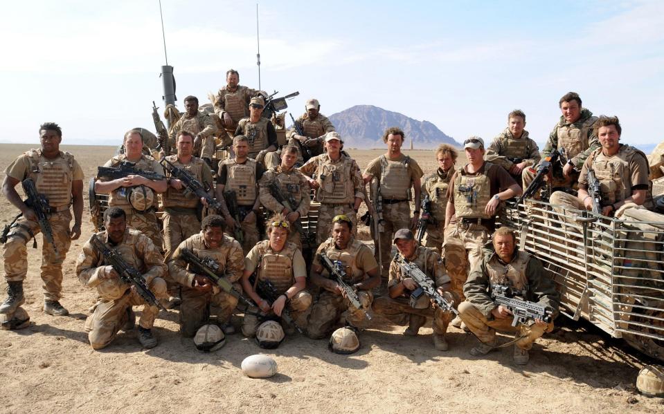 Nathan Hunt, bottom right, with soldiers in Helmand, Afghanistan, including Prince Harry, pictured above Mr Hunt