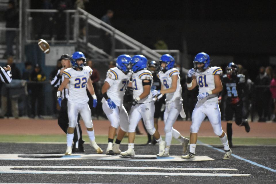 Rigo Cabral celebrates with teammates after scoring a 42-yard rushing touchdown to tie the game 14-14 against the Buena football team on Saturday night.