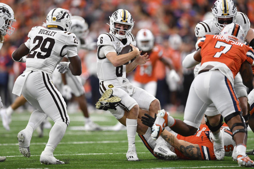 Western Michigan quarterback Jack Salopek (6) tries to spin away from the grasp of Syracuse defensive lineman Kevon Darton (0) during the first half of an NCAA college football game in Syracuse, N.Y., Saturday, Sept. 9, 2023. (AP Photo/Adrian Kraus)