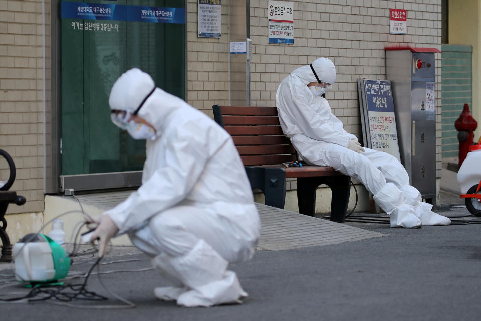 A medical worker takes a rest outside a hospital in Daegu, South Korea, February 23, 2020. Yonhap/Reuters