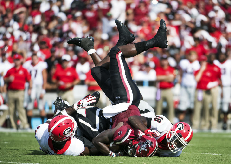 South Carolina wide receiver Deebo Samuel (1) is tackled by Georgia defensive back J.R. Reed, left, and Deandre Baker (18) during the first half of an NCAA college football game Saturday, Sept. 8, 2018, in Columbia, S.C. (AP Photo/Sean Rayford)