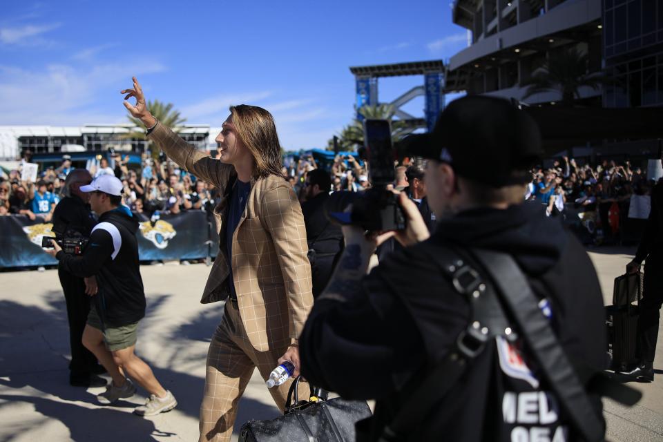 Jacksonville Jaguars quarterback Trevor Lawrence waves to the hundreds of fans who showed up Friday outside TIAA Bank Field to show their support and send off the team as they head to Kansas City to take on the Chiefs in the playoffs.