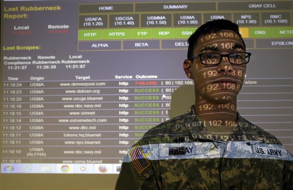 United States Military Academy cadet Kiefer Ragay stands in a projection of data results, as he talks to fellow cadets at the Cyber Research Center at the United States Military Academy in West Point, N.Y., Wednesday, April 9, 2014. The West Point cadets are fending off cyber attacks this week as part of an exercise involving all the service academies. The annual Cyber Defense Exercise requires teams from the five service academies to create computer networks that can withstand attacks from the National Security Agency and the Department of Defense. (AP Photo/Mel Evans)