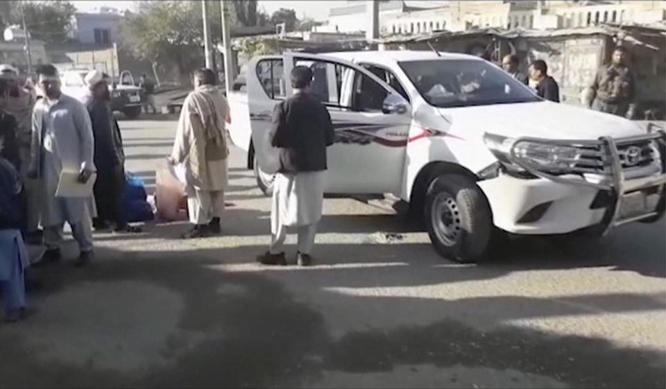 In this image made from video, locals inspect the site of a gun attack on a Japanese aid worker's truck Wednesday, Dec. 4, 2019, Nangarhar province, easter Afghanistan. Japanese physician and aid worker Tetsu Nakamura has died of his wounds after an attack that also killed five Afghans, including the doctor’s bodyguards, the driver and a passenger. (AP Photo)