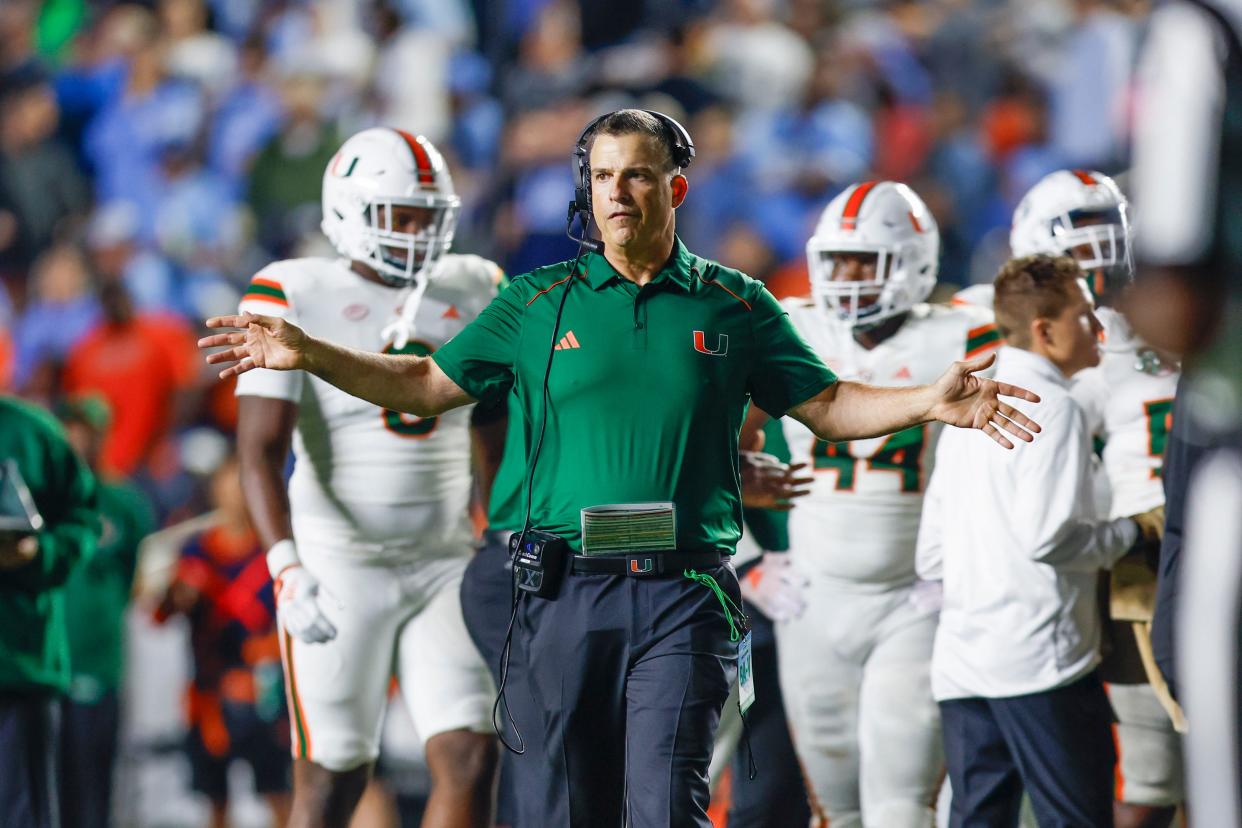 Oct 14, 2023; Chapel Hill, North Carolina, USA; Miami Hurricanes head coach Mario Cristobal stands on the field during a timeout as the Hurricanes play against the North Carolina Tar Heels in the second half at Kenan Memorial Stadium. Mandatory Credit: Nell Redmond-USA TODAY Sports