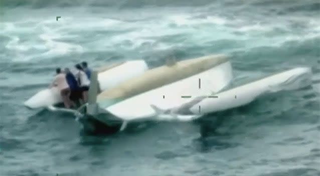 This family clung to the hull of their capsized trimaran as they waited to be rescued. Source: 7 News