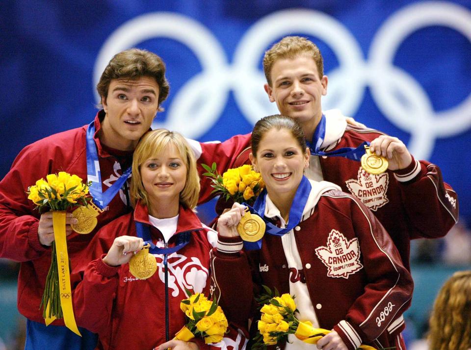 Canadian pairs figure skaters David Pelletier (back R) and Jamie Sale (front R) stand with their gold medals for their performance nearly a week earlier in which rival Russians, Yelena Berezhneya (front L) and Anton Sikharulidze (back L) were awarded the gold in a controversial judging decision, February 17, 2002. [The IOC decided to award second gold medals to the Canadians after an investigation into the judging of the competition turned up wrongdoing.]