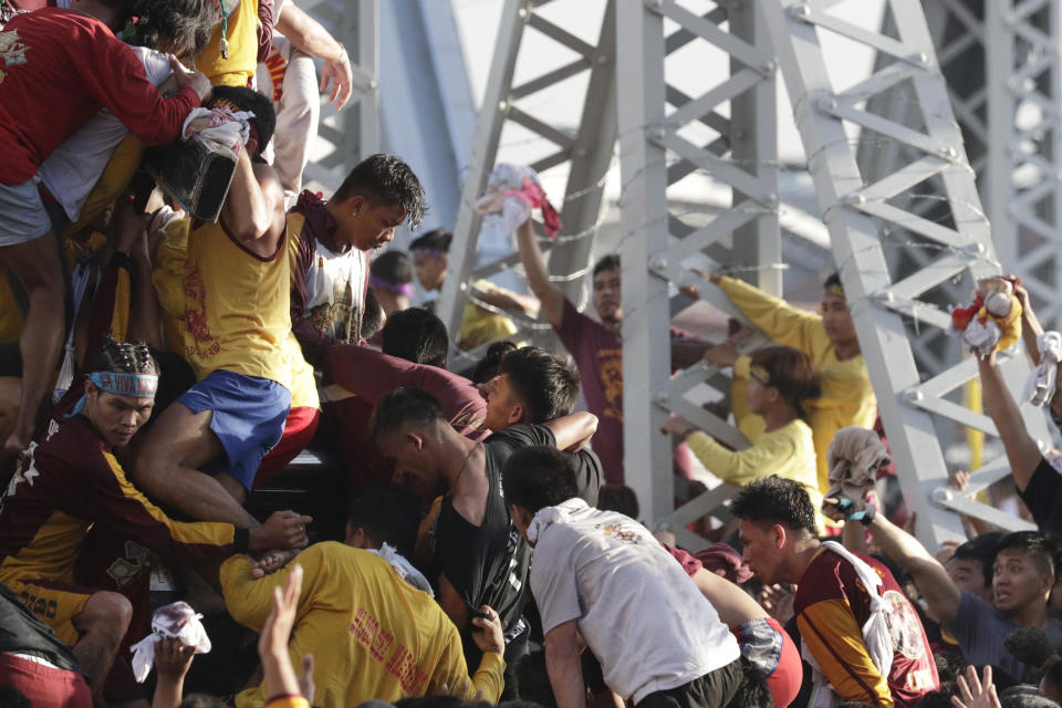 Filipino Roman Catholic devotees try to get near the carriage of the Black Nazarene during a raucous procession to celebrate its feast day Thursday, Jan. 9, 2020, in Manila, Philippines. A mammoth crowd of mostly barefoot Filipino Catholics prayed for peace in the increasingly volatile Middle East at the start Thursday of an annual procession of a centuries-old black statue of Jesus Christ in one of Asia's biggest religious events. (AP Photo/Aaron Favila)