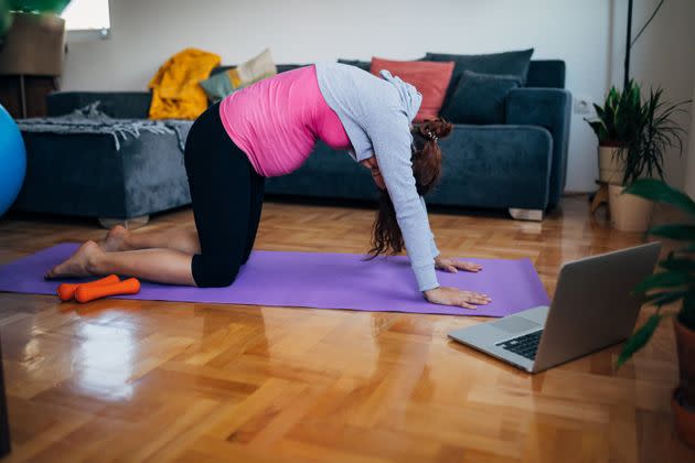 A cat-cow yoga pose can help take some of the tension off your back and neck. (Photo: Kosamtu via Getty Images)