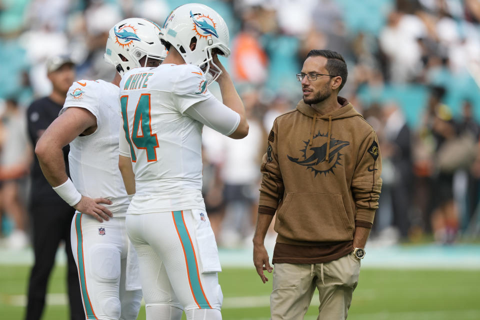 Miami Dolphins head coach Mike McDaniel talks to quarterback Mike White (14) before an NFL football game against the Las Vegas Raiders, Sunday, Nov. 19, 2023, in Miami Gardens, Fla. (AP Photo/Rebecca Blackwell)