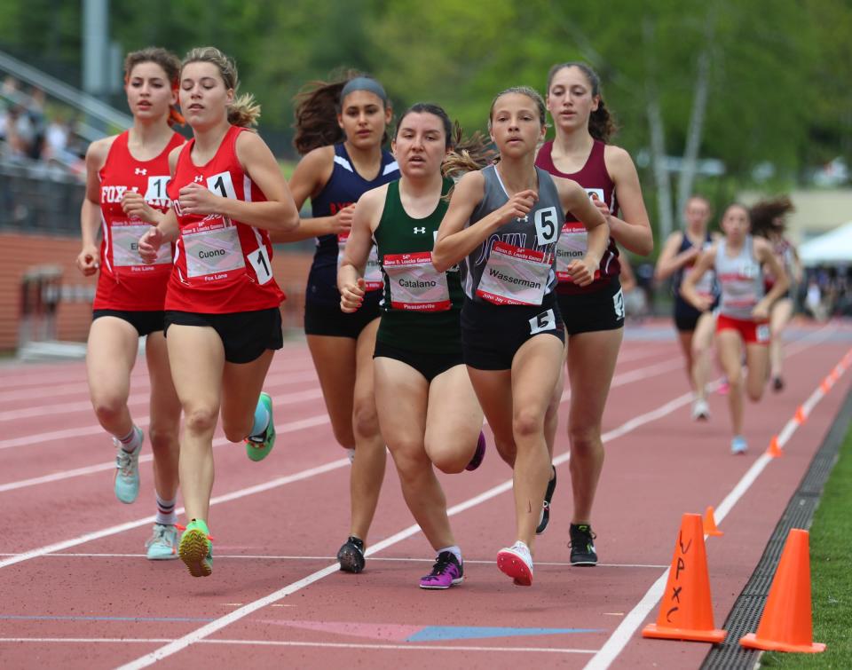 John Jay-Cross River's Sloan Wasserman (r, No. 5) and Pleasantville's Ariana Catalano (to her left in green) compete in the Section-1 mile during Day 3 of the Loucks Games track and field meet at White Plains High School on Saturday, May 14, 2022.