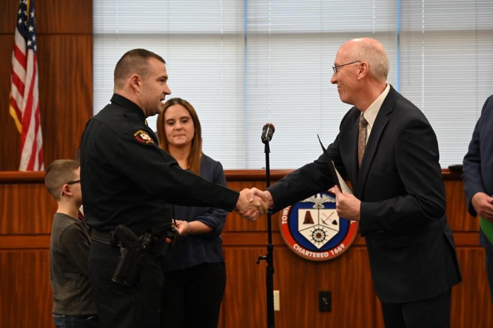 Newly promoted Lt. Benjamin Stevenson is congratulated by Township Clerk John Mitch.