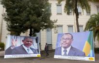 A man walks near photographs of Ethiopian Prime Minister Hailemariam Desalegn and US President Barack Obama outside the National Palace in Addis Ababa on July 27, 2015