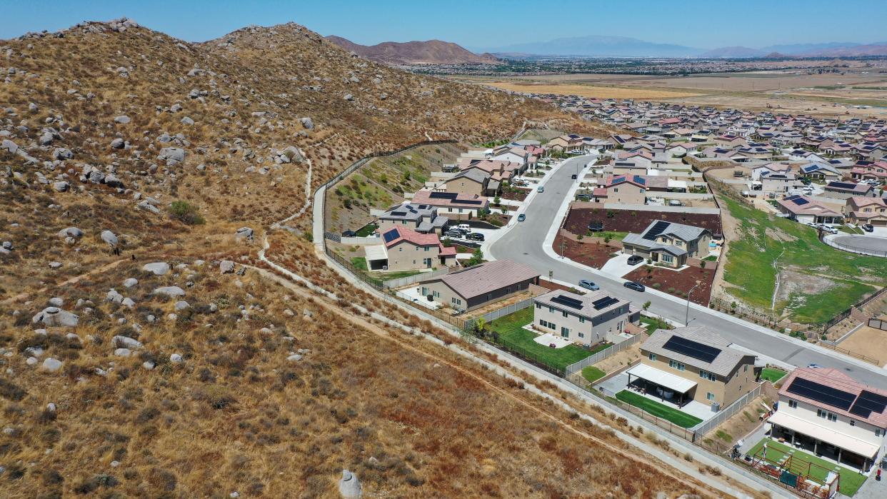 Newly built homes border the natural hillside vegetation in the Winchester Ridge development in Winchester, Calif., Aug. 18, 2023.