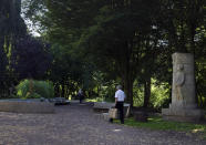 In this photo taken on Wednesday, June 24, 2020, a man walks with his shopping bags past the Monument for the Congo Pioneers in Halle, Belgium. In Halle, a small trading town of 40,000, as across much of Europe, the tide is turning and a new consciousness is taking shape in the wake of the Black Lives Matter movement in the United States. (AP Photo/Virginia Mayo)