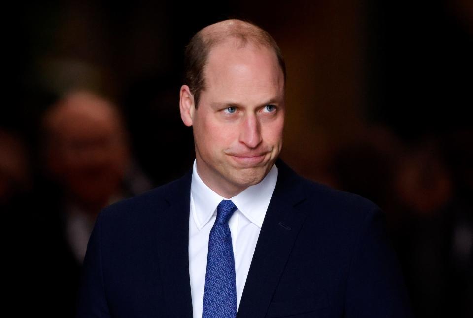 Prince William smiles with his mouth closed.