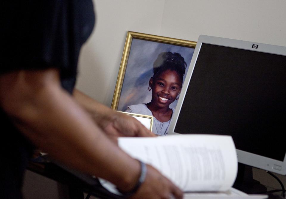 Patricia Jackson sifts through bank documents as a picture of her daughter Nakawe sits on the desk in their home Saturday, June 16, 2012, in Marietta, Ga. On a suburban cul-de-sac northwest of Atlanta, the Jacksons are struggling to keep a house worth $100,000 less than they owe. Their voices and those of many others tell the story of a country that, for all the economic turmoil of the past few years, continues to believe things will get better. But until it does, families are trying to hang on to what they've got left. The Great Recession claimed nearly 40 percent of Americans' wealth, the Federal Reserve reported last week. The new figures, showing Americans' net worth has plunged back to what it was in 1992, left economists shuddering. (AP Photo/David Goldman)