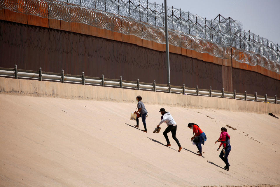 Asylum-seeking migrants walk near the border wall after crossing the Rio Bravo river, in El Paso, Texas, U.S., as seen from Ciudad Juarez, Mexico April 6, 2022.<span class="copyright">Jose Luis Gonzalez—Reuters</span>