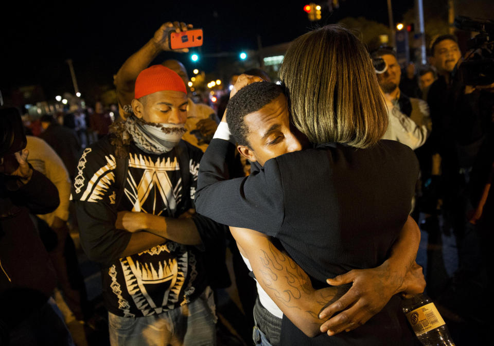 State Sen. Catherine E. Pugh, right, D-Baltimore, embraces a protestor while urging the crowd to disperse ahead of a 10 p.m. curfew in the wake of Monday's riots following the funeral for Freddie Gray, Tuesday, April 28, 2015, in Baltimore. (AP Photo/David Goldman)