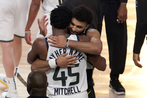 Utah Jazz's Donovan Mitchell (45) and Denver Nuggets' Jamal Murray, center rear, greet each other after their NBA first round playoff basketball game, Tuesday, Sept. 1,2020, in Lake Buena Vista, Fla. The Nuggets won 80-78. (AP Photo/Mark J. Terrill)