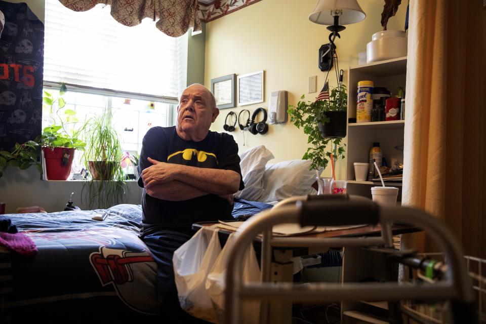 In this March 6, 2020, photo, Vietnam War veteran Leo Marchand, 71, sits in his room at the South Shore Rehabilitation and Skilled Care Center, in Rockland, Mass. Marchand said he's concerned because he'd be among those considered most at risk if exposed to the coronavirus. The Vietnam War vet and retired truck driver has respiratory problems and is prone to getting pneumonia. (AP Photo/David Goldman)