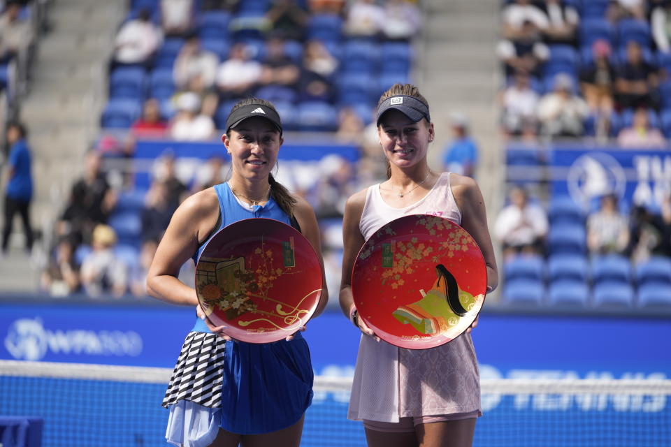 Veronika Kudermetova of Russia, right, holding her champion trophy, and Jessica Pegula of the U.S. with her runner-up trophy, pose for a photo during the award ceremony for the singles in the Pan Pacific Open tennis tournament in Tokyo, Sunday, Oct. 1, 2023. (AP Photo/Hiro Komae)