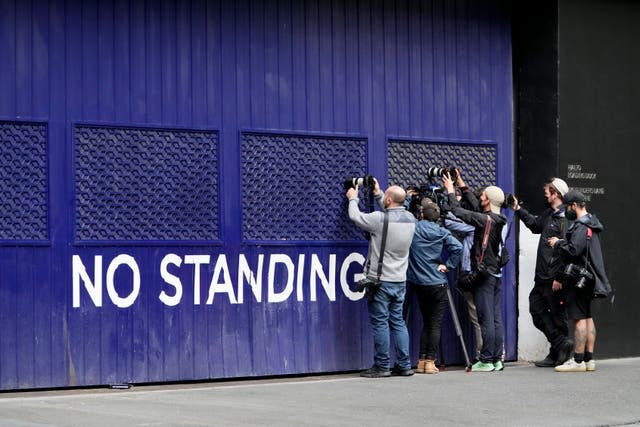 Photographers attempt to take a picture outside a building that houses the office of Novak Djokovic's lawyers