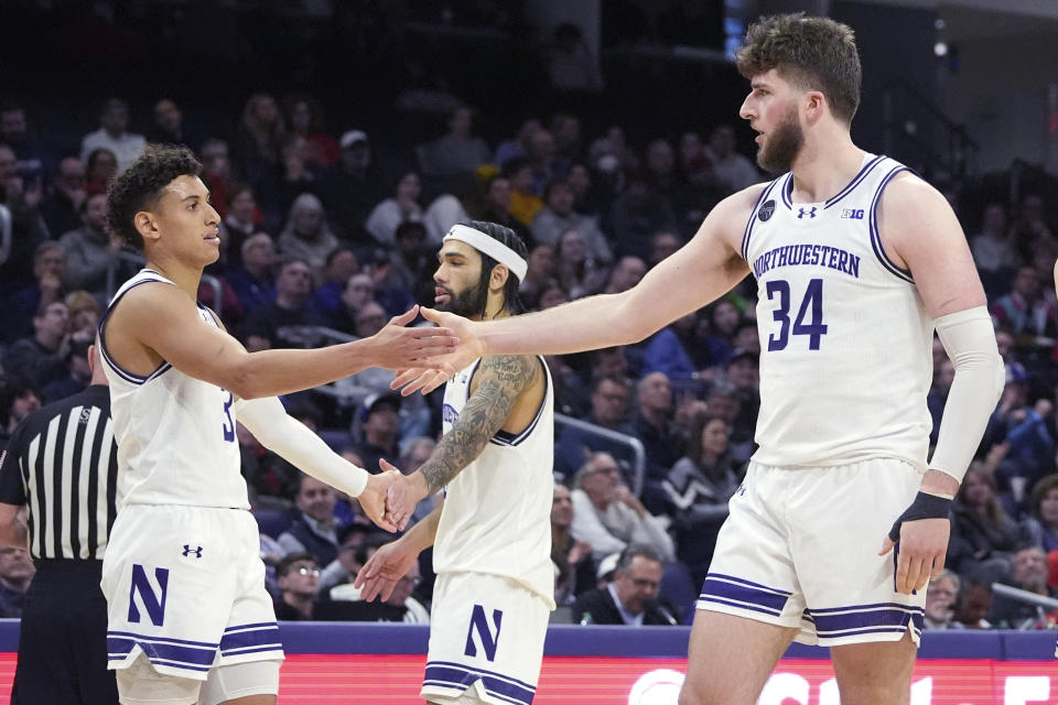 Northwestern guard Ty Berry, left, celebrates with guard Boo Buie, center, and center Matthew Nicholson during the second half of the team's NCAA college basketball game against Maryland in Evanston, Ill., Wednesday, Jan. 17, 2024. (AP Photo/Nam Y. Huh)