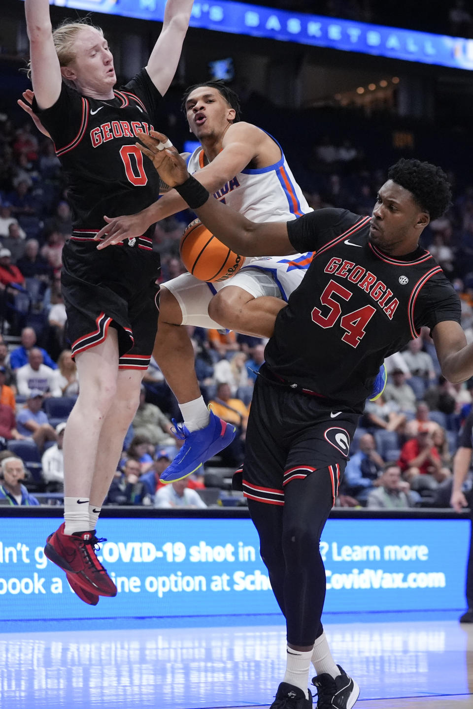 Florida guard Will Richard (5) loses control of the ball as he tries to go between Georgia's Blue Cain (0) and Russel Tchewa (54) during the second half of an NCAA college basketball game at the Southeastern Conference tournament Thursday, March 14, 2024, in Nashville, Tenn. (AP Photo/John Bazemore)