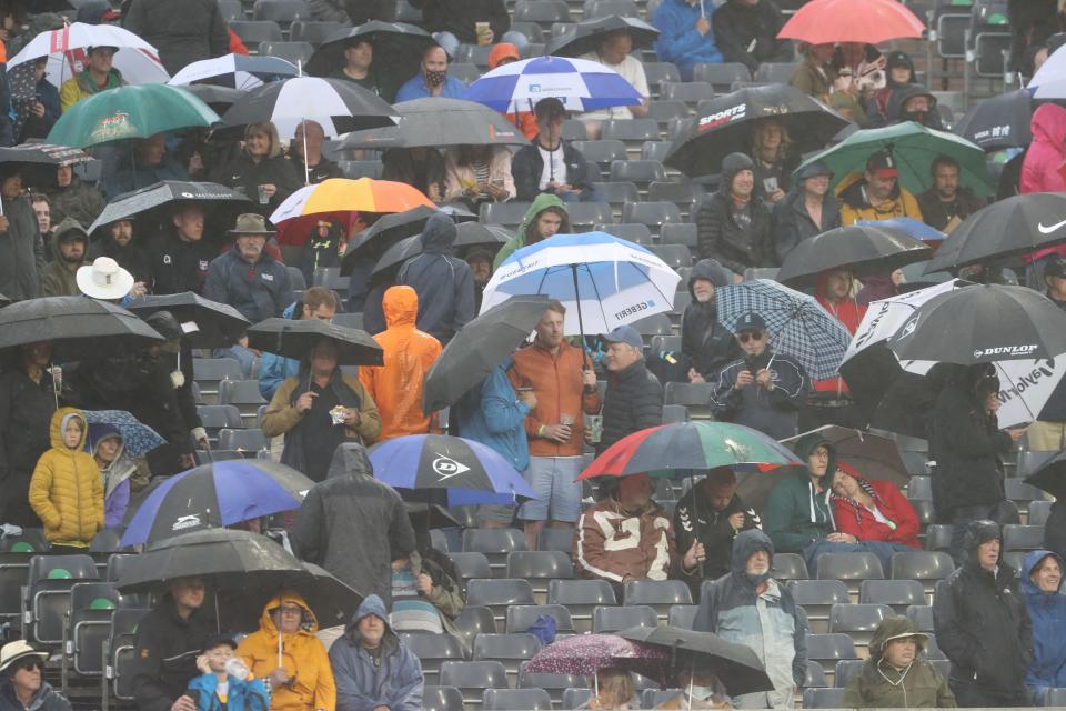 Fans try to evade the rain at Bristol on Sunday (AFP via Getty Images)