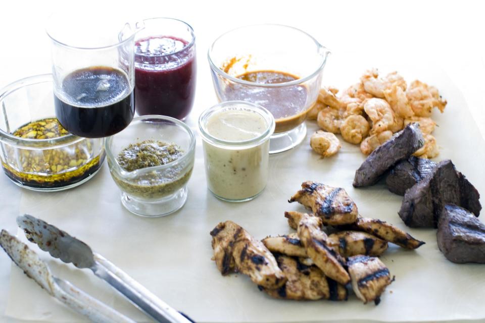 This July 29, 2013 photo shows, from left, marinades of garlic balsamic, maple soy, lemon herb, raspberry ginger, white wine mustard and orange cumin in Concord, N.H. On the meat, from top, are chipolte lime, red wine and rosemary and spicy hoisin. (AP Photo/Matthew Mead)