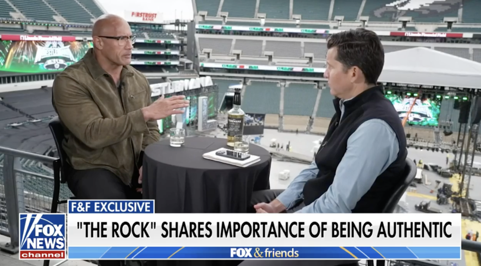 Dwayne "The Rock" Johnson in an interview on a stadium's upper deck for FOX News, sharing thoughts on authenticity