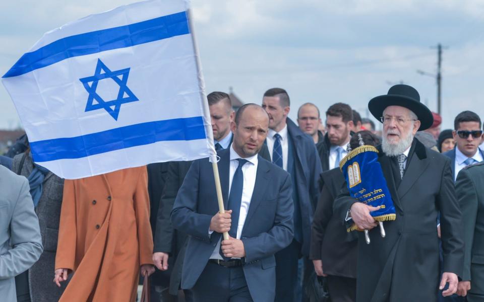 Naftali Bennett (holding flag) and Rabbi Yisrael Meir Lau, the Chief Rabbi of Tel Aviv and Chairman of Yad Vashem, participating in the March of the Living in 2017 - NurPhoto 