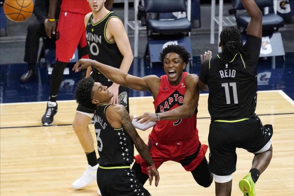 Toronto Raptors' Stanley Johnson (5) gets off a pass from between Minnesota Timberwolves' Jaden McDaniels (3) and Naz Reid (11) during the second half of an NBA basketball game Friday, Feb. 19, 2021, in Minneapolis. (AP Photo/Jim Mone)