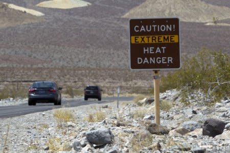 FILE PHOTO: A sign warns of extreme heat as tourists enter Death Valley National Park in California June 29, 2013. The high temperature reached 128 degrees fahrenheit. REUTERS/Steve Marcus