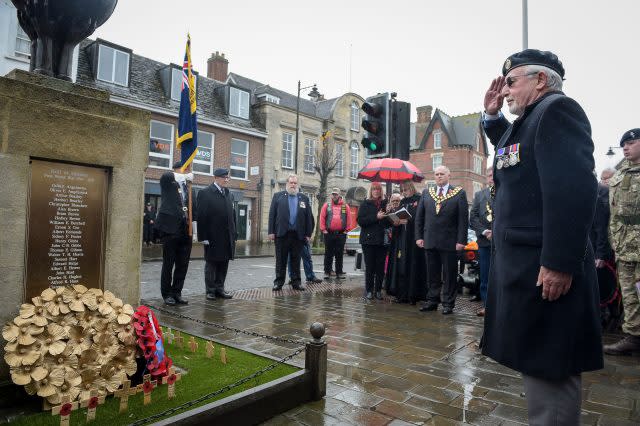 A member of the Royal British Legion salutes after laying a wreath at the war memorial at Royal Wootton Bassett