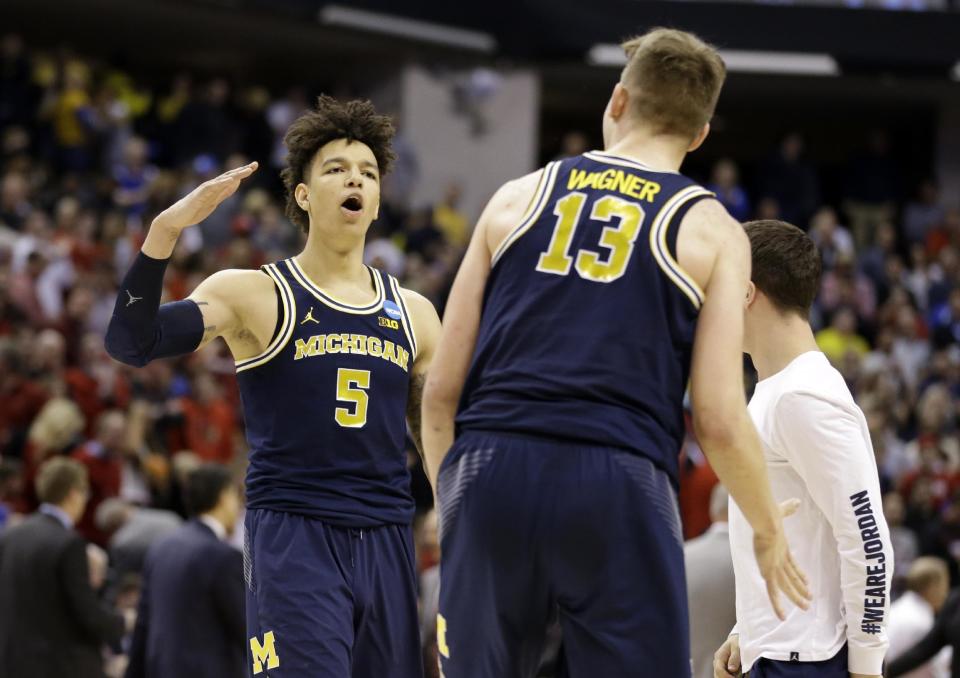 Michigan forward Moritz Wagner (13) and forward D.J. Wilson (5) celebrates a 73-69 win over Louisville in a second-round game in the men’s NCAA college basketball tournament in Indianapolis, Sunday, March 19, 2017. (AP Photo/Michael Conroy)