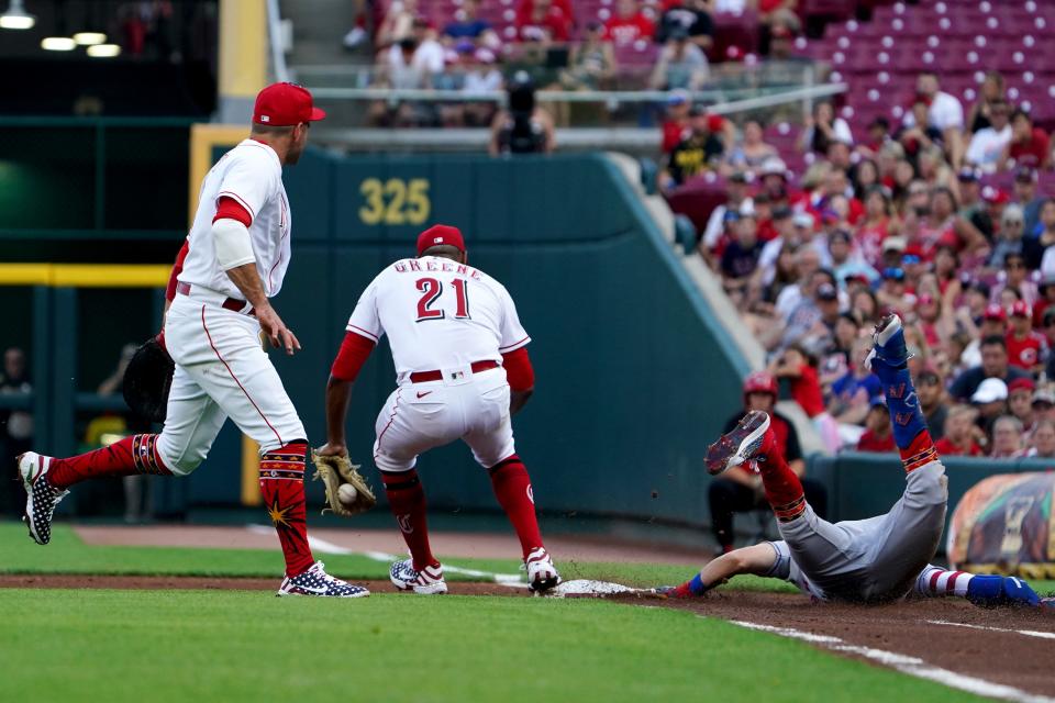 New York Mets second baseman Jeff McNeil (1) reaches first base safely as Cincinnati Reds starting pitcher Hunter Greene (21) attempts to tag first base in time during the first inning of a baseball game, Monday, July 4, 2022, at Great American Ball Park in Cincinnati.