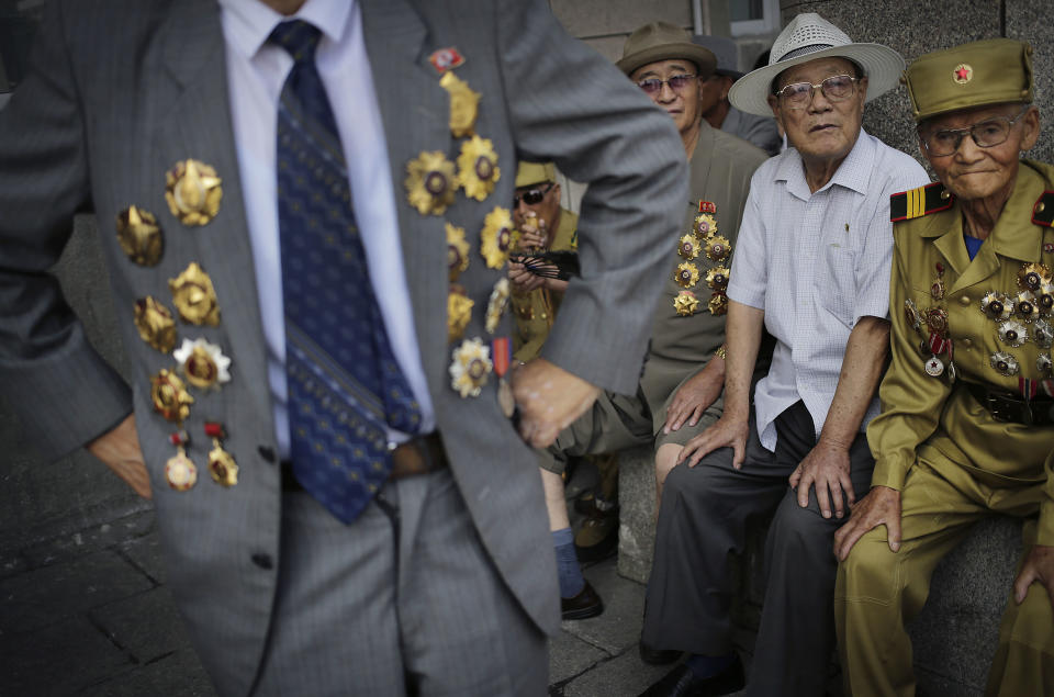 North Korean war veteran, Kim Hak Chol, 81, a retired soldier, right, together with other veterans decorated with medals, attend a parade to celebrate the anniversary of the Korean War armistice agreement, Sunday, July 27, 2014, in Pyongyang, North Korea. North Koreans gathered at Kim Il Sung Square as part of celebrations for the 61st anniversary of the armistice that ended the Korean War. (AP Photo/Wong Maye-E)