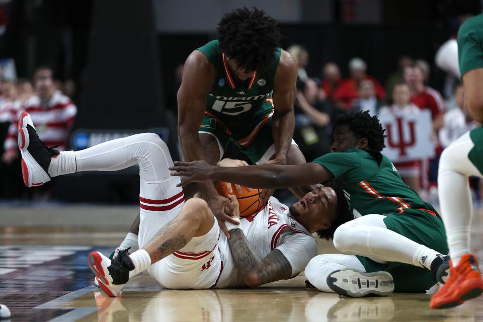 ALBANY, NEW YORK - MARCH 19: Jalen Hood-Schifino #1 of the Indiana Hoosiers competes for a loose ball with Bensley Joseph #4 and Norchad Omier #15 of the Miami Hurricanes in the first half during the second round of the NCAA Men's Basketball Tournament at MVP Arena on March 19, 2023 in Albany, New York.