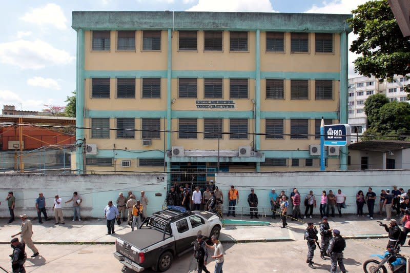 People gather outside the public school Tasso da Silveira, located in the Realengo neighborhood in Rio de Janeiro, where 12 children were killed in a shooting April 7, 2011. File Photo by Antonio Lacerda/EPA