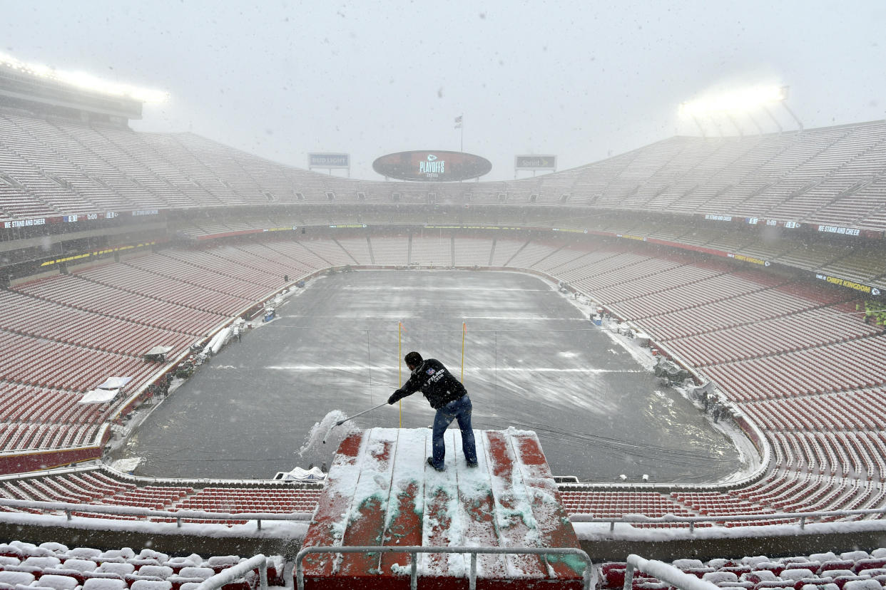 Kyle Haraugh, of NFL Films, clears snow from a camera location at Arrowhead Stadium before last Saturday’s NFL divisional football playoff game between the Kansas City Chiefs and the Indianapolis Colts. (AP Photo/Ed Zurga)