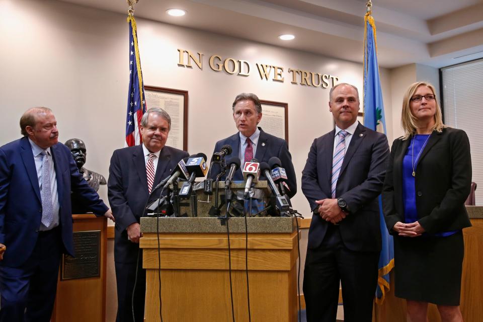 Oklahoma Attorney General Mike Hunter, center, answers a question during a news conference after the announcement of an opioid lawsuit decision in Norman, Okla., on  Aug. 26, 2019. Pictured from left are attorneys Reggie Whitten, Michael Burrage, Hunter, attorney Brad Beckworth and Terri White, Commissioner, Oklahoma Department of Mental Health and Substance Abuse Services.
